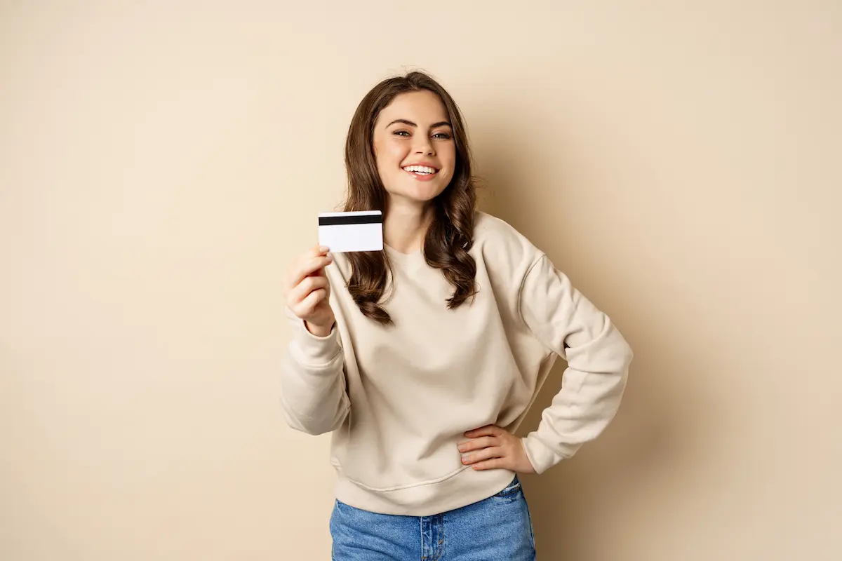 Mujer con una tarjeta de crédito en la mano lista para hacer sus compras.