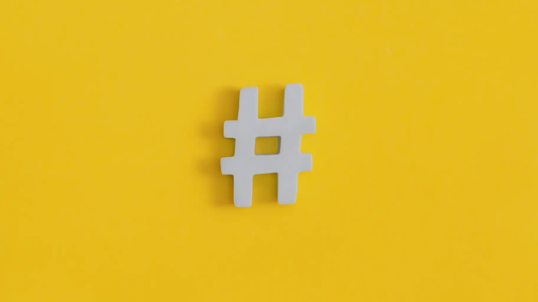 Símbolo de hashtag blanco con fondo amarillo.